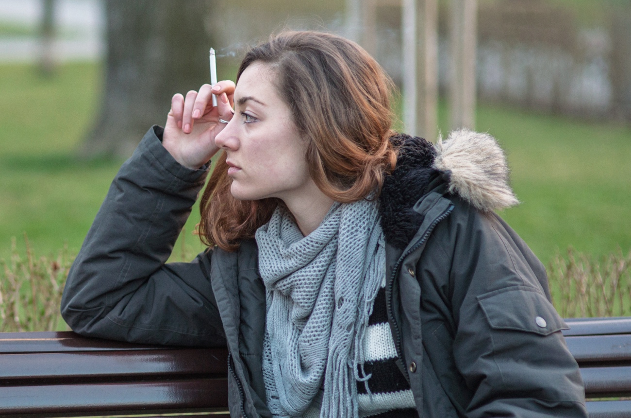 woman on bench smoking a cigarette